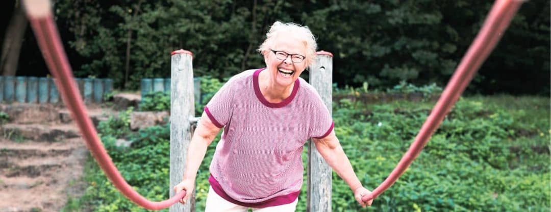 senior balancing on rope bridge